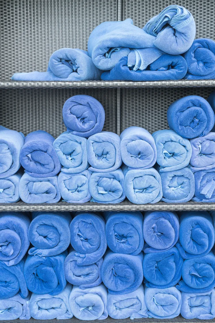 Rows of folded and rolled blue towels